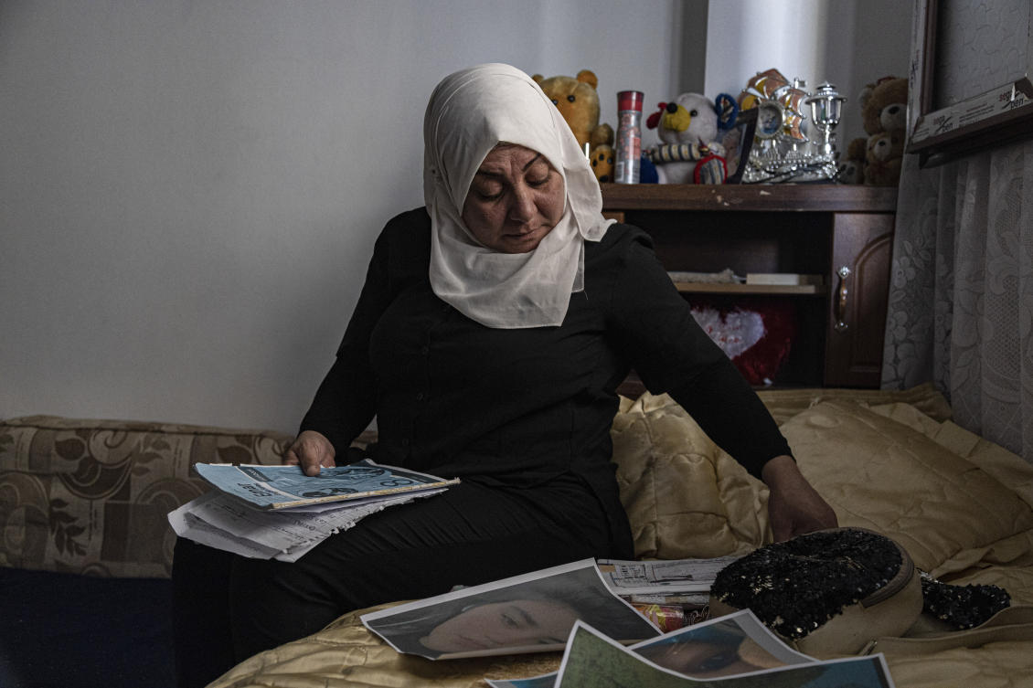 Hamrin Alouji, mother of 13-year-old Peyal Aqil, goes through her daughter's photographs at their family home in Qamishli, Syria. (AP)