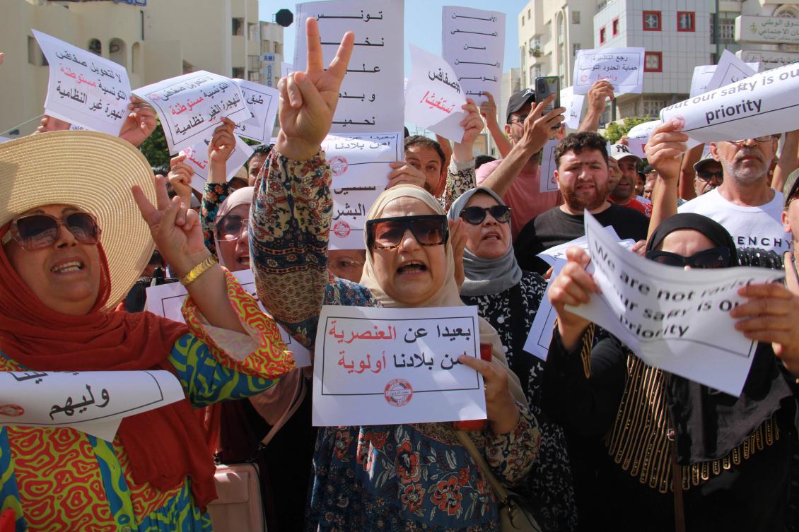 People lift placards as they shout slogans during a demonstration against the presence of illegal sub-Saharan migrants, in Sfax the second largest city in Tunisia, is the starting point for a large number of illegal migrants trying to reach Italy. (AFP)
