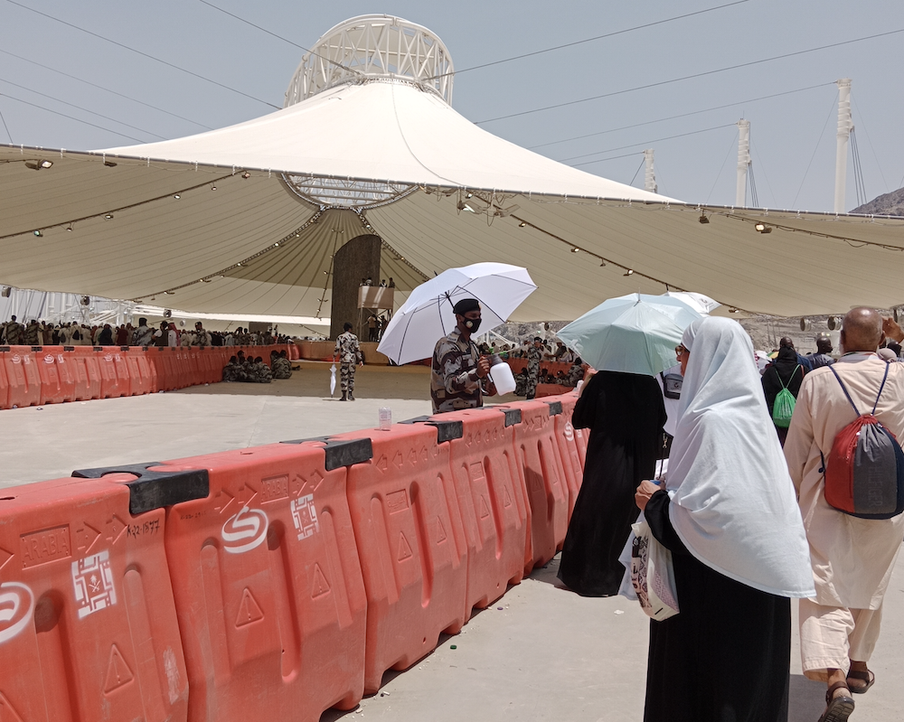 Abdullah Salim of the Special Emergency Force sprays pilgrims with water at the Jamarat complex. (AN photos by Rashid Hassan)