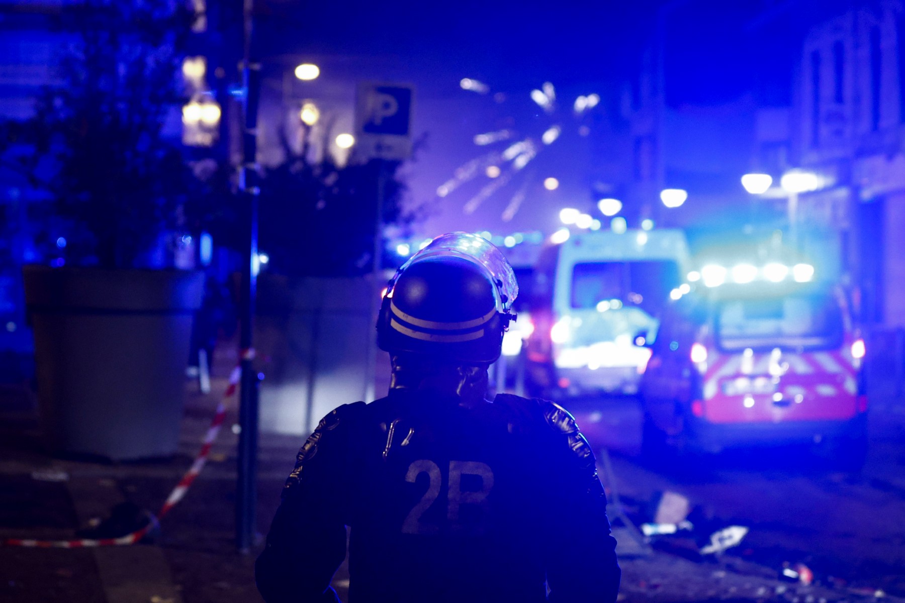 Fireworks explode as policemen stand by during protests in Roubaix, northern France on June 30, 2023, three days after a teenager was shot dead during a police traffic stop in the Paris suburb of Nanterre (AFP)