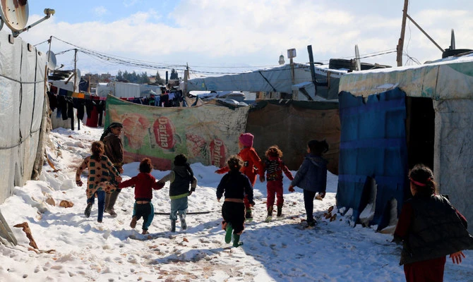 Syrian children run amidst snow in the Syrian refugees camp in Lebanon’s Bekaa valley. (AFP)