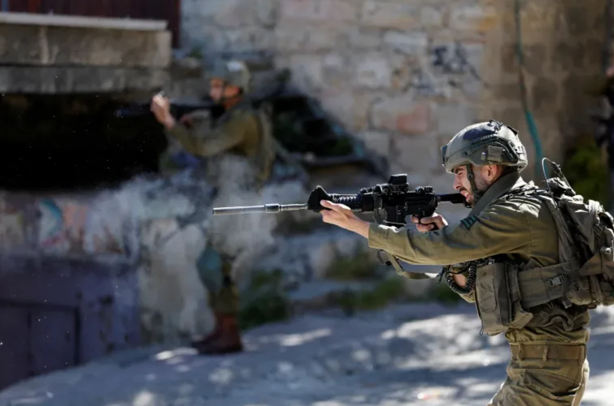 An Israeli soldier shoots rubber bullets at Palestinians in Hebron in the Israeli-occupied West Bank. (Reuters/File Photo)