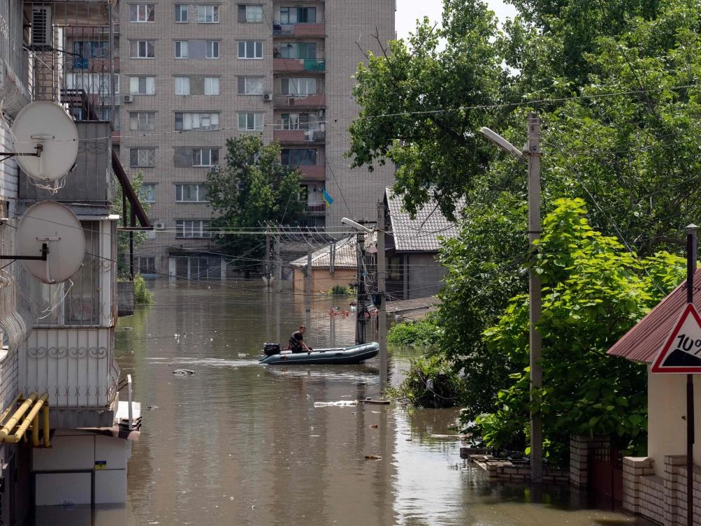 A local resident rides on a boat during an evacuation from a flooded area in Kherson on Jun. 7, 2023, following damages sustained at Kakhovka hydroelectric power plant dam. (AFP)