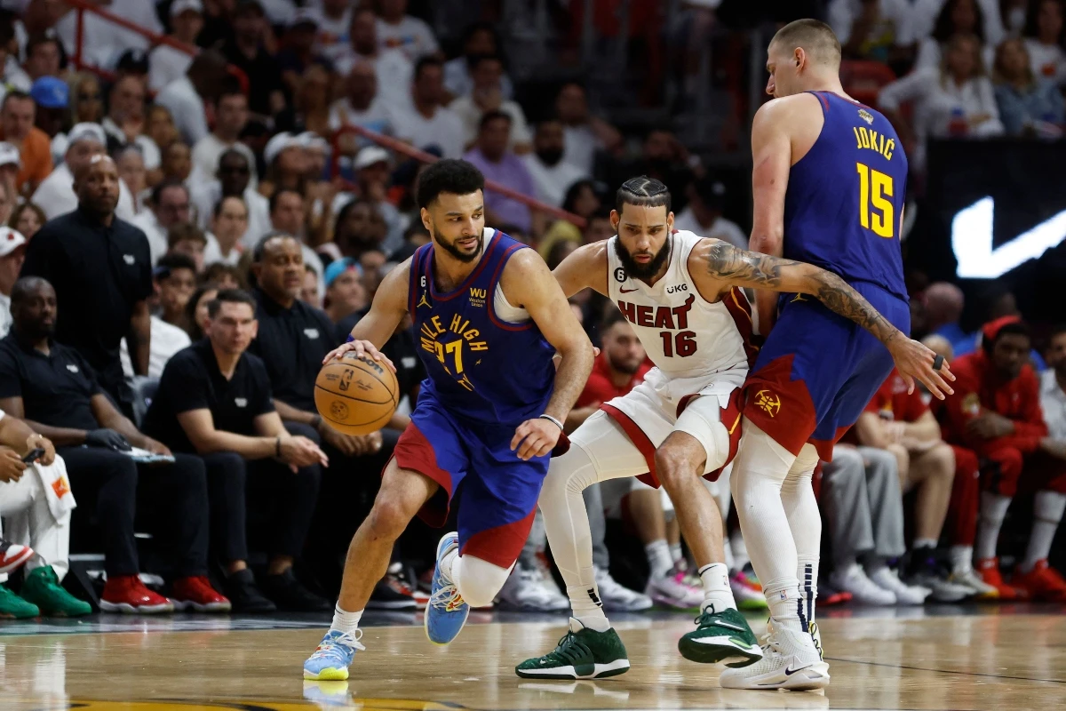 Jamal Murray of the Denver Nuggets dribbles past a screen set by Nikola Jokic against Caleb Martin #16 of the Miami Heat during the fourth quarter in Game 3 of the 2023 NBA Finals at Kaseya Center on Wednesday in Miami, Florida. (GETTY IMAGES NORTH AMERICA / AFP)