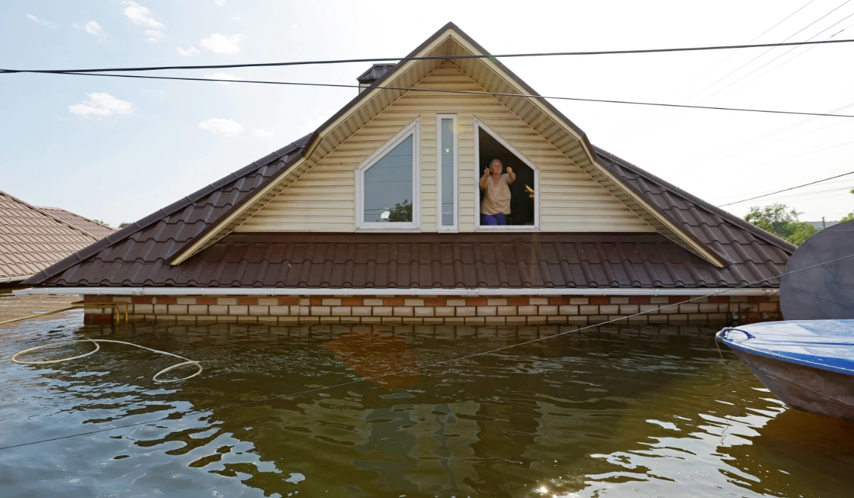 A woman who refuses to be evacuated from a flooded house gestures towards the rescuers following the collapse of the Nova Kakhovka dam in the course of Russia-Ukraine conflict, in the town of Hola Prystan in the Kherson region, Russian-controlled Ukraine, June 8, 2023. (REUTERS)