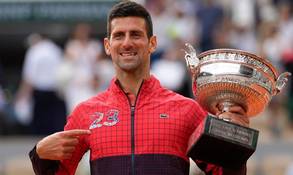 Serbia's Novak Djokovic points at 23 on his garment as he celebrates winning the men's singles final of the French Open tennis tournament against Norway's Casper Ruud in three sets, 7-6, (7-1), 6-3, 7-5, at the Roland Garros stadium in Paris, Sunday. (AP)