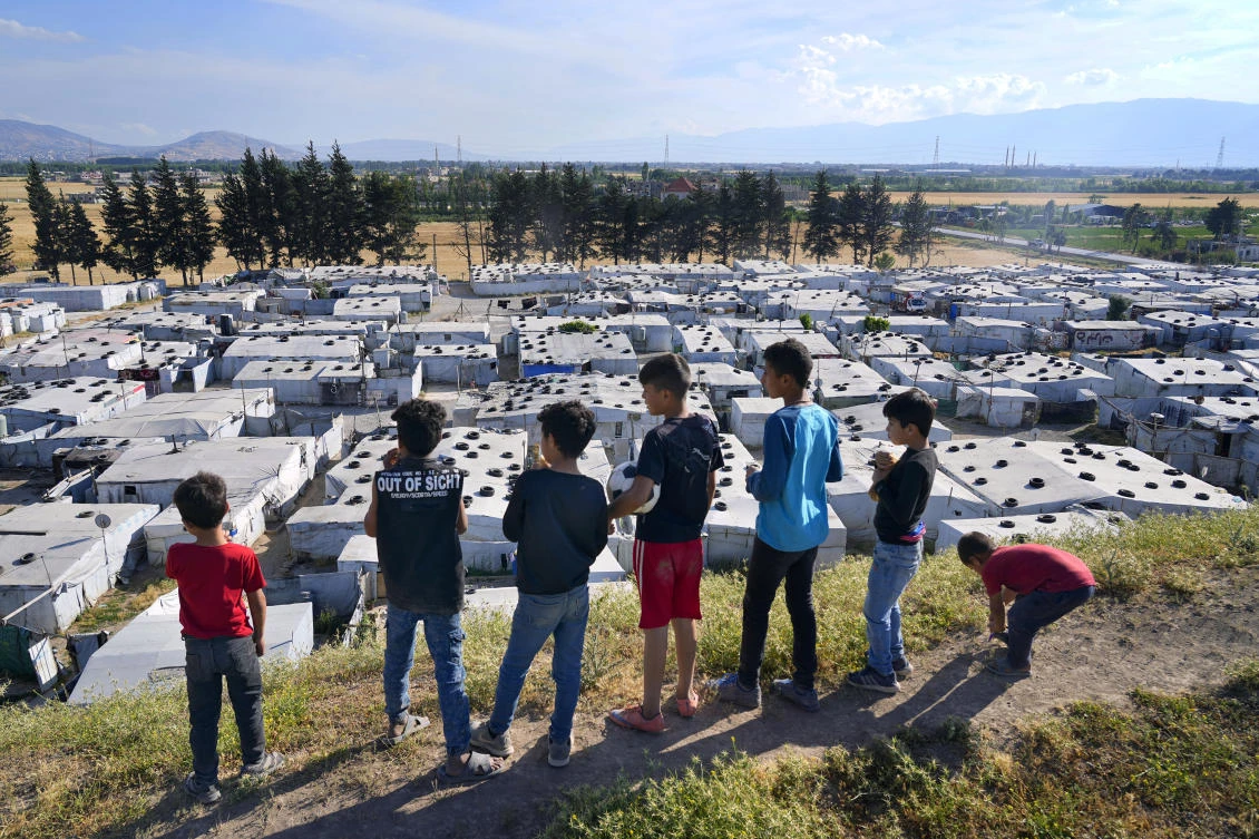 Syrian children stand on a hill above a refugee camp in the town of Bar Elias, in Lebanon's Bekaa Valley, Tuesday, June 13, 2023. (AP Photo/Bilal Hussein)