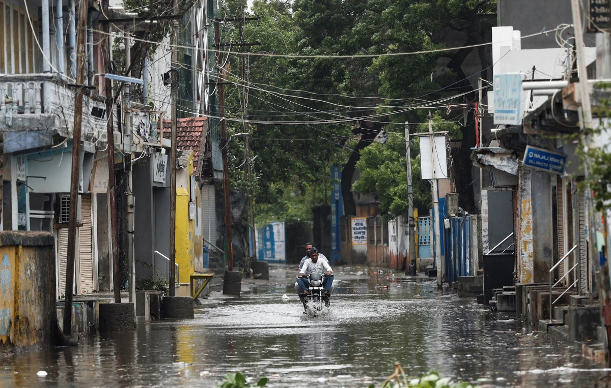 A man rides a motorcycle through a waterlogged street in Mandvi before the arrival of cyclone Biparjoy in the western state of Gujarat, India, on June 15, 2023. (Reuters)
