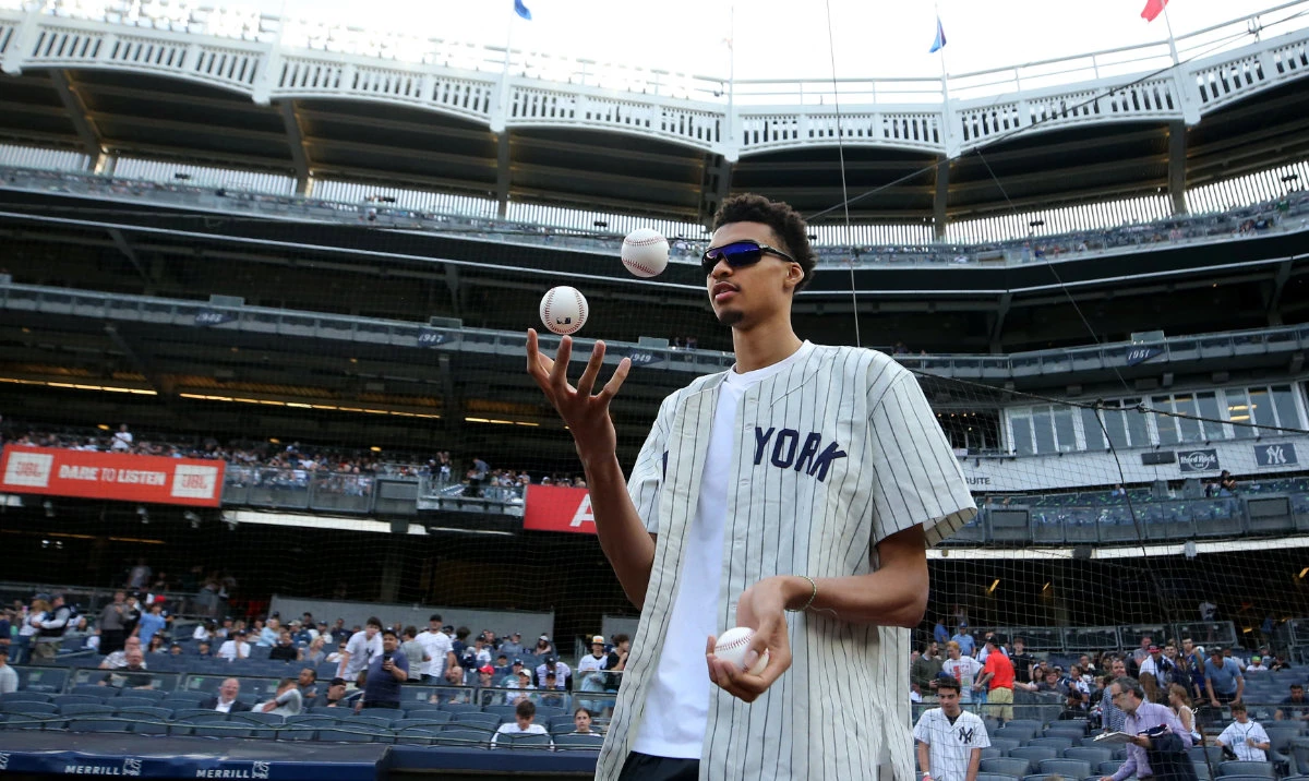 French NBA draft prospect Victor Wembanyama juggles baseballs before throwing out a ceremonial first pitch before a game between the New York Yankees and the Seattle Mariners at Yankee Stadium. (Reuters)