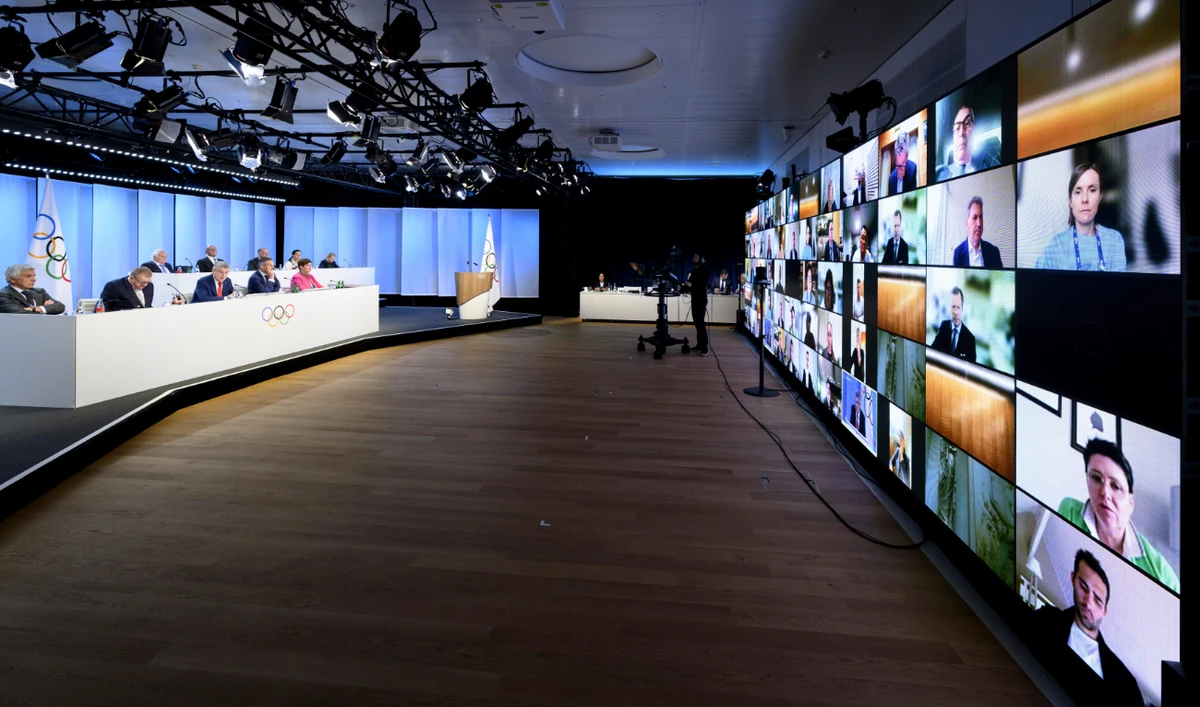 International Olympic Committee members appear on a giant screen in Lausanne on Thursday during an extraordinary hybrid IOC Session. (AFP)
