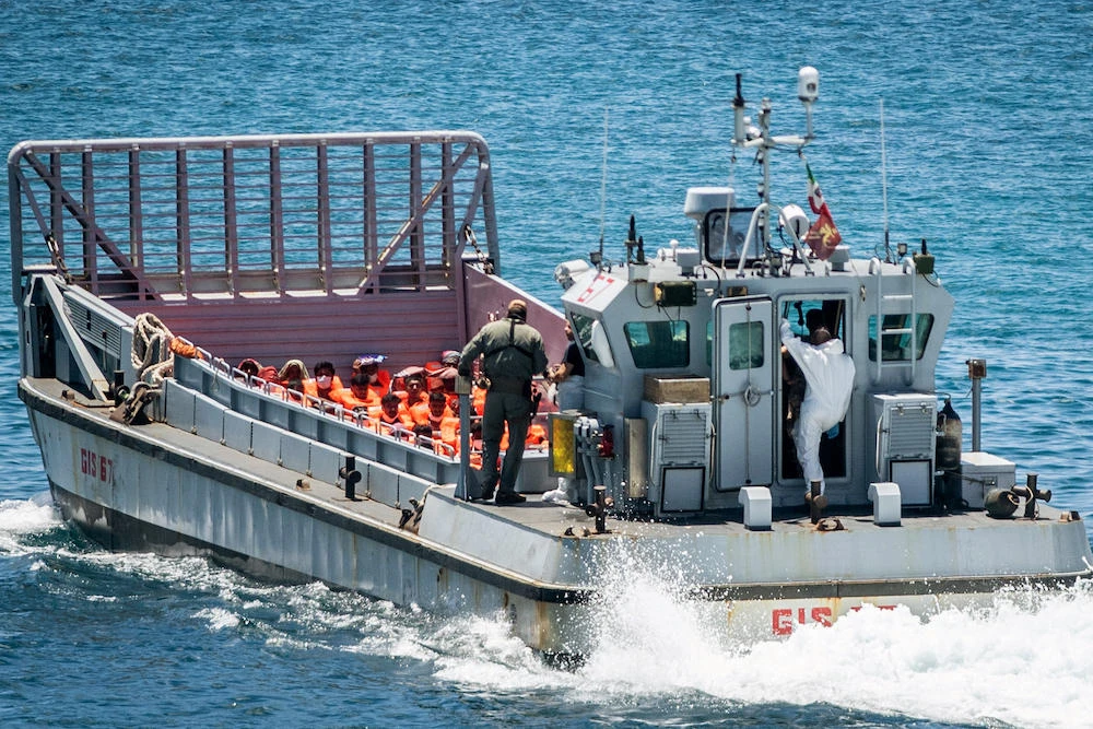Above, migrants aboard an Italian military vessel are transferred from a processing facility on the southern Italian island of Lampedusa on July 11, 2022. (AFP)