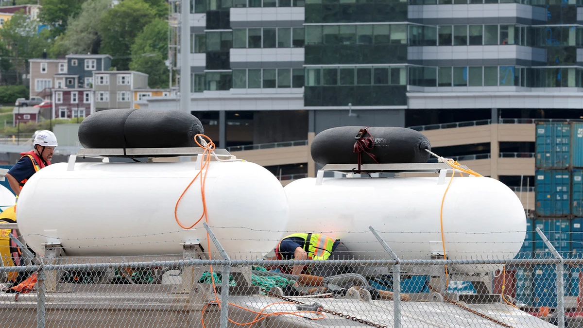 People inspect Polar Prince ship and the deployment barge, used with the Titan submersible carrying five people to explore the wreck of the sunken Titanic, as the Transportation Safety Board of Canada began its investigation into the loss of the submersible from OceanGate Expeditions, at the St. John's harbour, Newfoundland, Canada on June 25, 2023. (REUTERS)