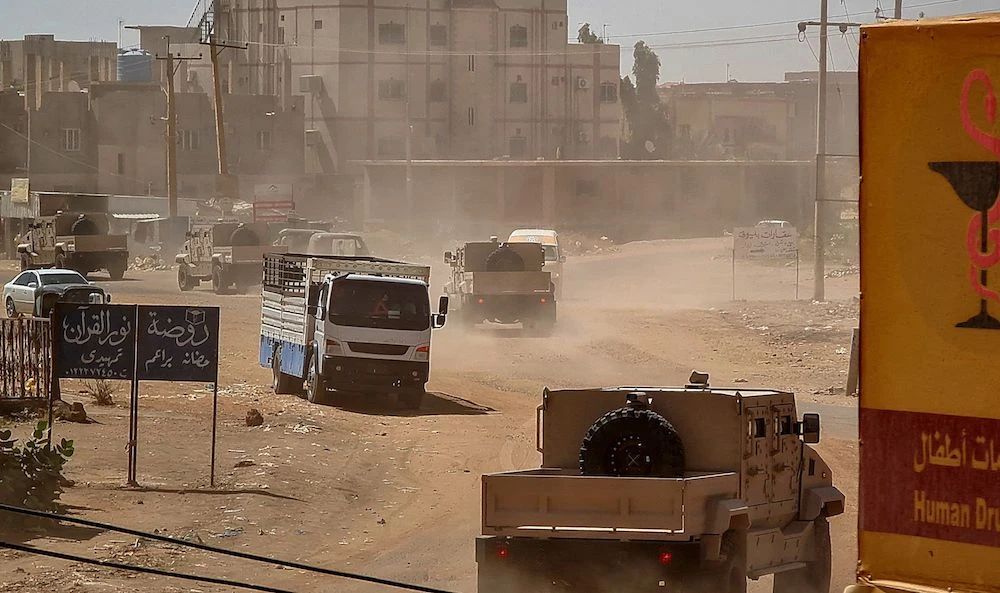 Sudanese army armored vehicles drive in a street in Khartoum, on June 26, 2023. Sudan’s army today faced a multi-front challenge after losing a Khartoum police headquarters to paramilitaries in a battle that killed at least 14 civilians, while rebels attacked troops. (AFP)