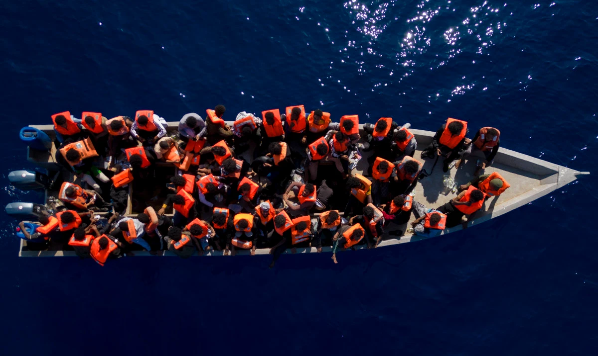 Migrants from Eritrea, Libya and Sudan sail a wooden boat in the Mediterranean sea, about 30 miles north of Libya. (AP)