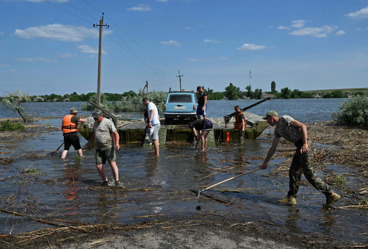 Ukrainian servicemen evacuate residents from the flooded village of Afanasiivka, Mykolaiv region on June 9, 2023. (AFP)