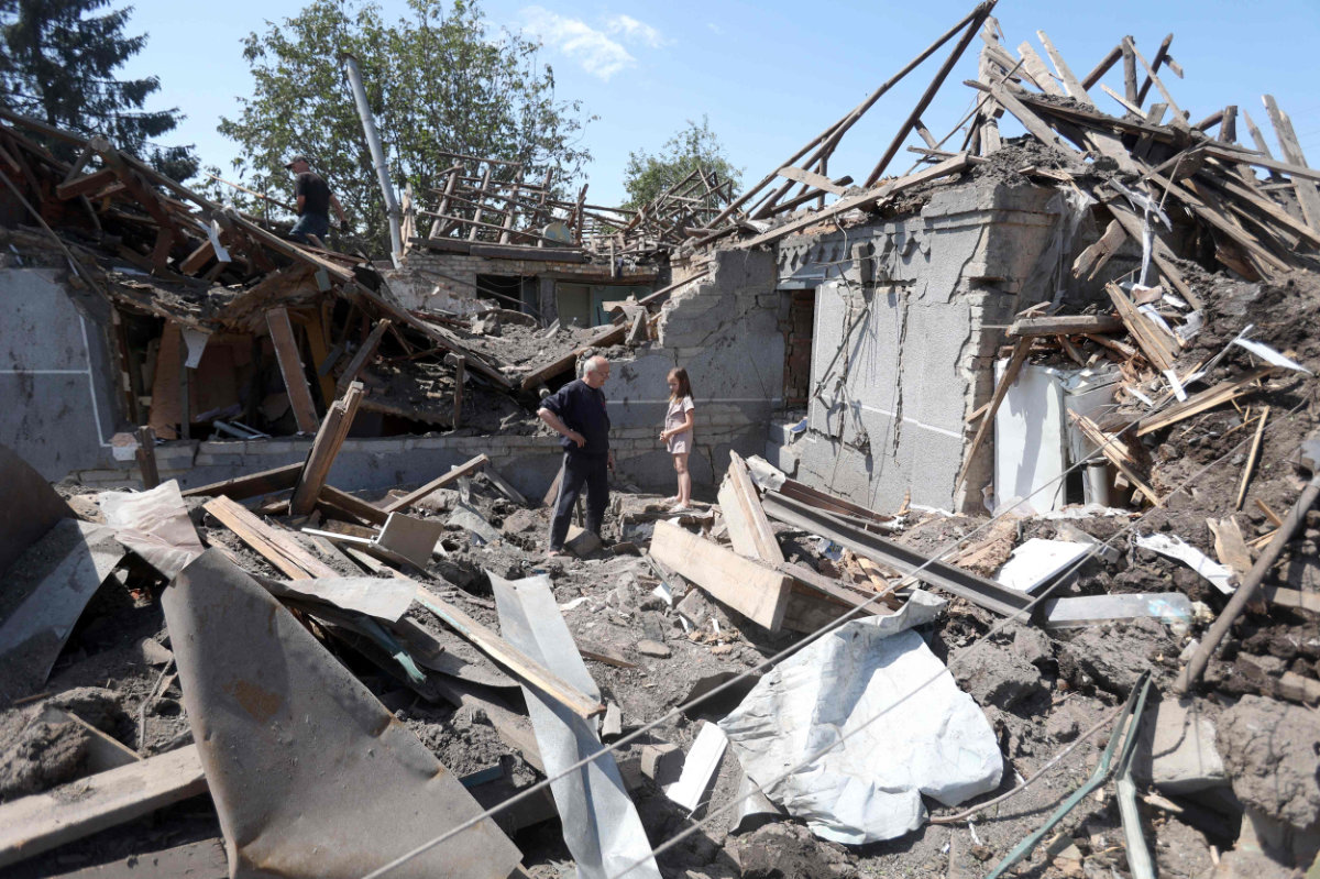 Residents stand in the remains of their homes in the aftermath of a Russian attack on Kramatorsk on June 14, 2023. (AFP)