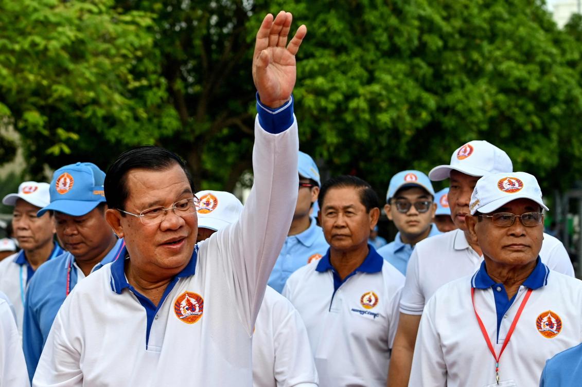 Cambodia’s prime minister Hun Sen, left, is running unopposed after the main opposition party was prevented from running. (AFP)