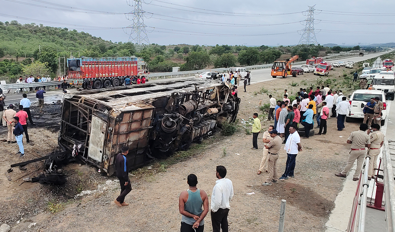 People gather around the wreckage of a bus that caught fire along the Samruddhi Expressway near Sindkhed Raja in Buldhana district of Maharashtra state on July 1, 2023. (AFP)