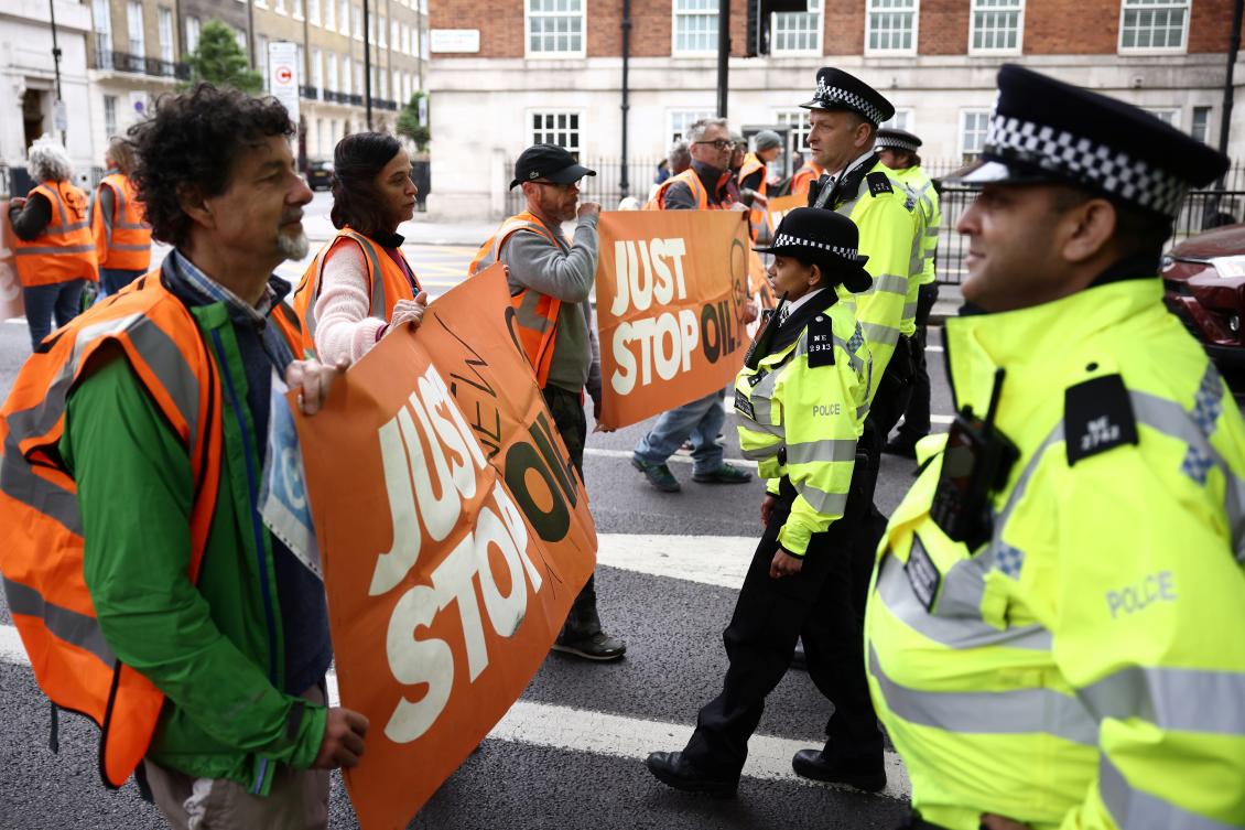 Just Stop Oil climate activists face police officers as they march in London. (File/AFP)