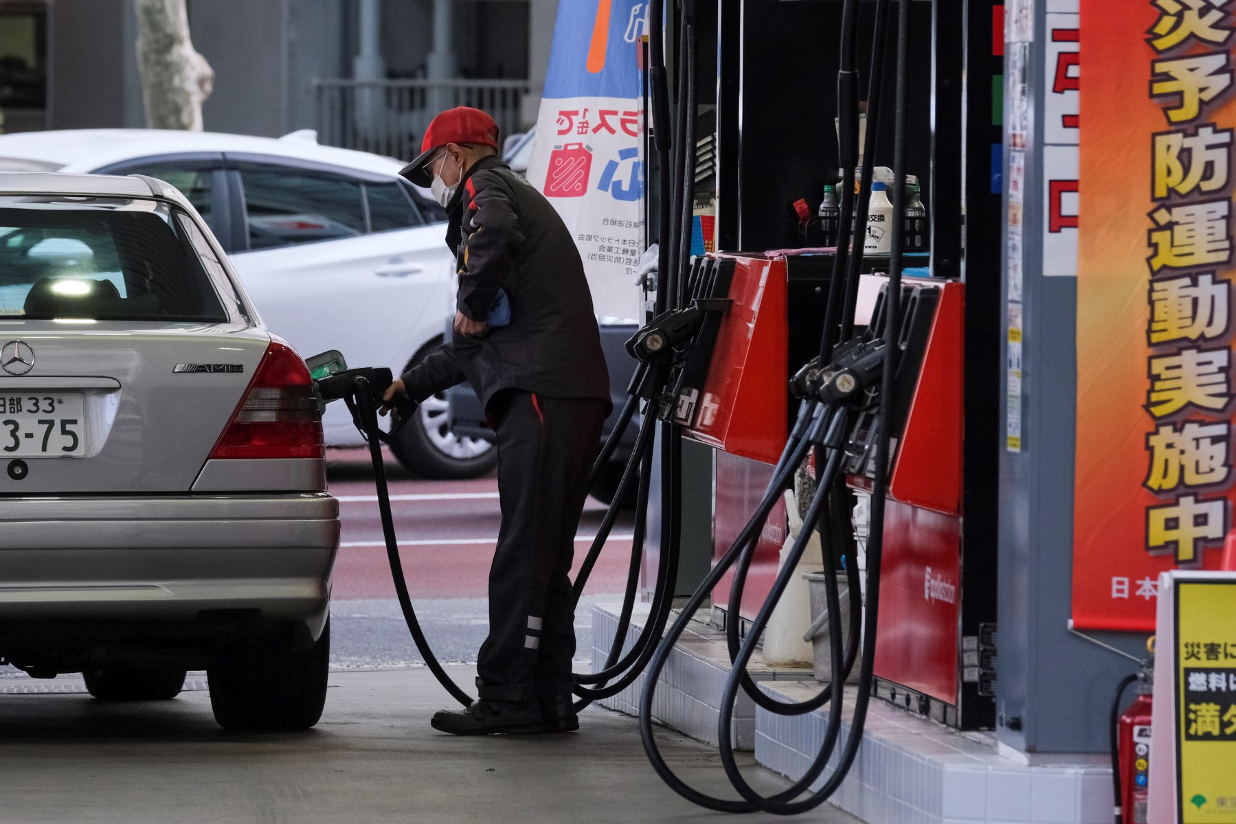 A service station attendant fills up a vehicle at a petrol station in Tokyo (AFP)