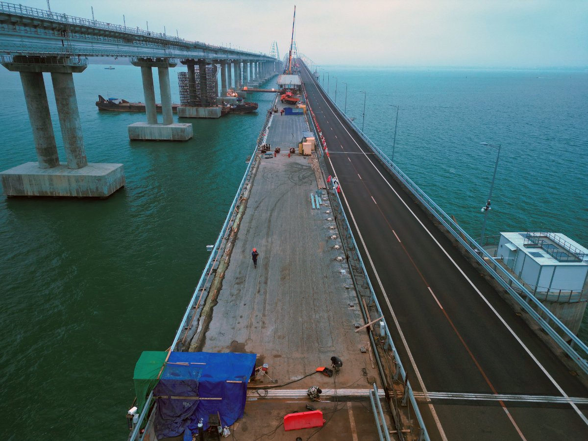 This aerial picture taken on January 31, 2023 shows restoration works on damaged parts of the Kerch Bridge that links Crimea to Russia, which was hit by a blast on October 8, 2022. (Russian federal road agency Rosavtodor handout via AFP)