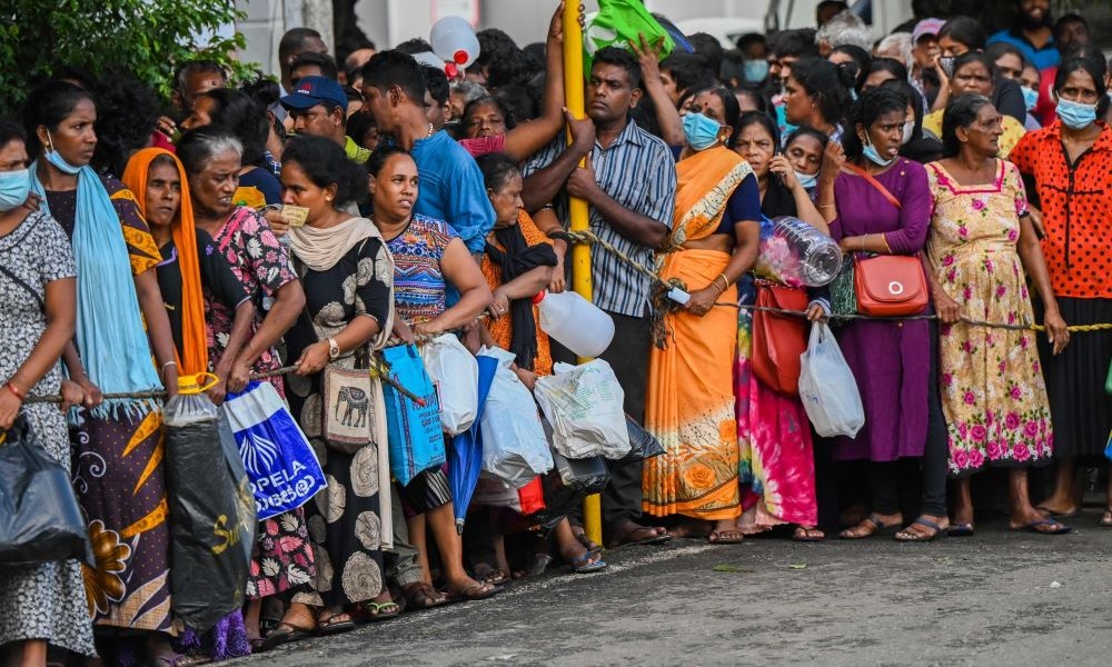 Sri Lankans queue to buy kerosene for domestic use at a supply station in Colombo on May 26, 2022. (AFP)