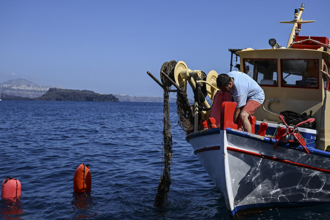 A fishing vessel retrieves a ghost net. (File/AFP)