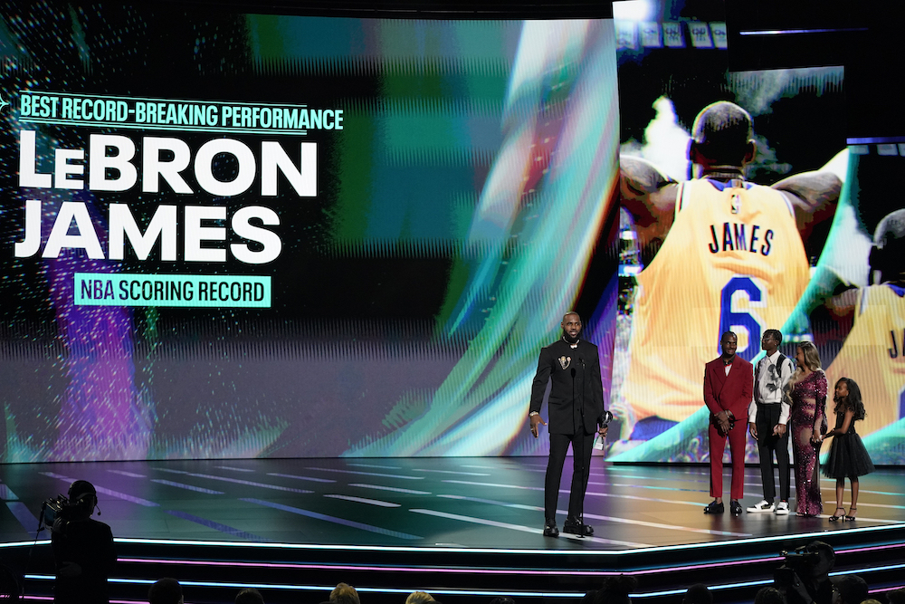 NBA superstar LeBron James of the Los Angeles Lakers, left, accepts the award for best record-breaking performance is his family watches at the ESPY awards on Wednesday at the Dolby Theatre in Los Angeles. (AP)