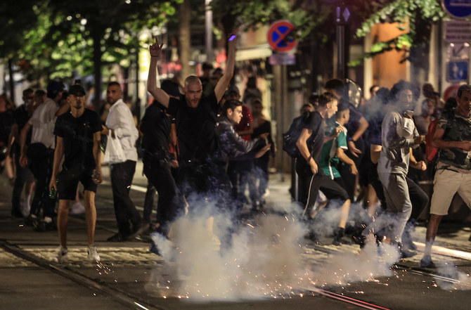 Protestors flee from an exploding firework on a street in Nice, France early July 2. (AFP/File)