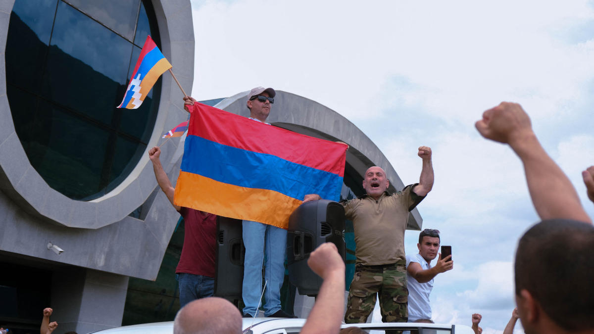 Demonstrators hold a flag during a rally to demand the reopening of a blockaded road linking the Nagorno-Karabakh region to Armenia and to decry crisis conditions in the region, in Stepanakert on July 14, 2023. (AFP)