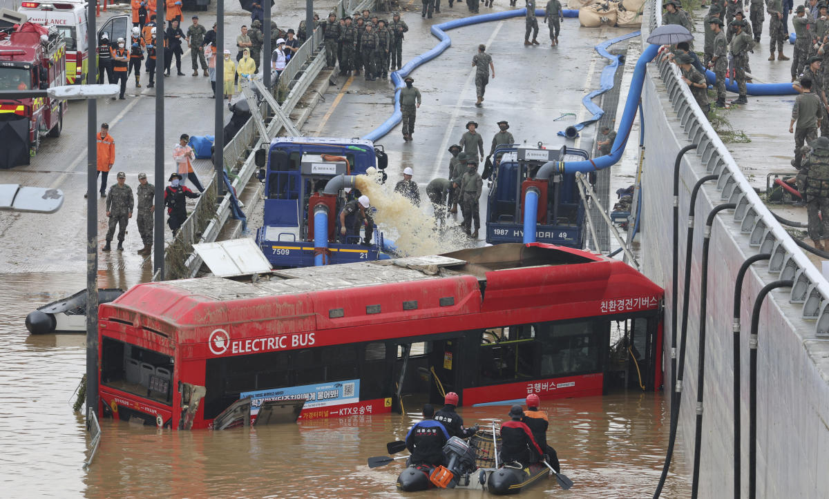 Rescuers search for survivors along a road submerged by floodwaters leading to an underground tunnel in Cheongju, South Korea on July 16, 2023. (Yonhap via AP)