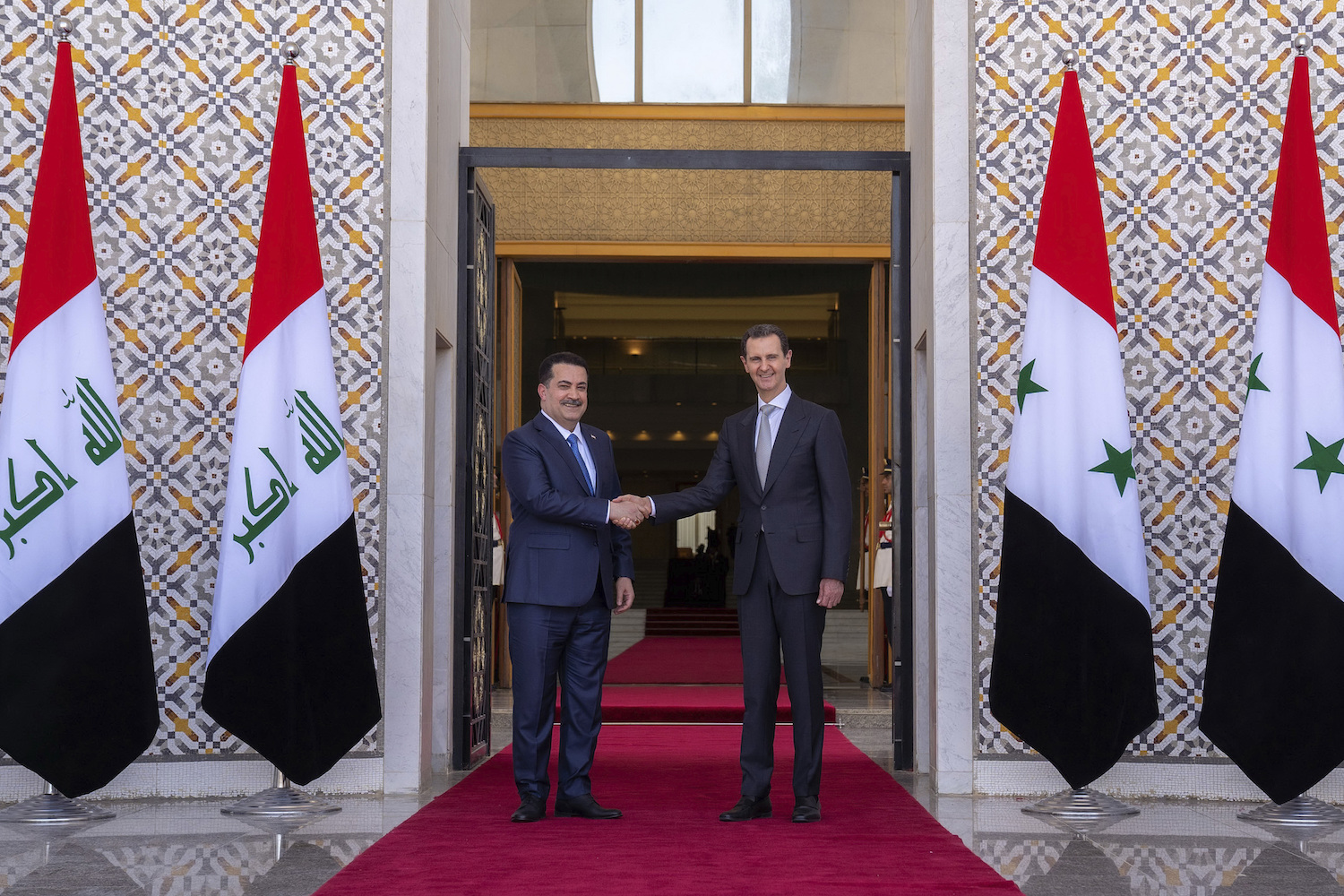 Syrian President Bashar Assad welcomes Iraq's Prime Minister Mohammed Shia Al-Sudani during a ceremony in Damascus, Syria, Sunday, July 16, 2023. (AP)