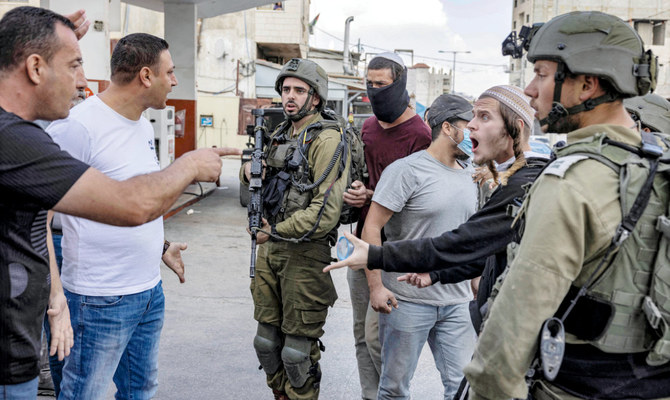 Palestinian men confront Israeli settlers while soldiers stand by during recent clashes in the town of Huwara in the occupied West Bank. (File/AFP)