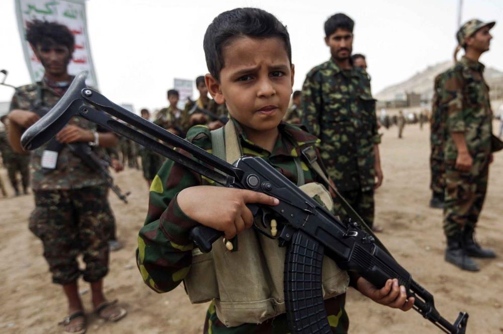 A Yemeni boy poses with a Kalashnikov at a Houthi rally in Sanaa in July 2017. (AFP)