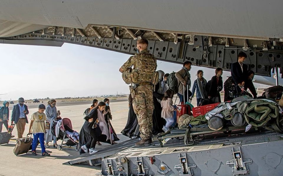 Afghans board a UK military aircraft at Kabul airport, Afghanistan, Aug. 16, 2021. (Reuters)