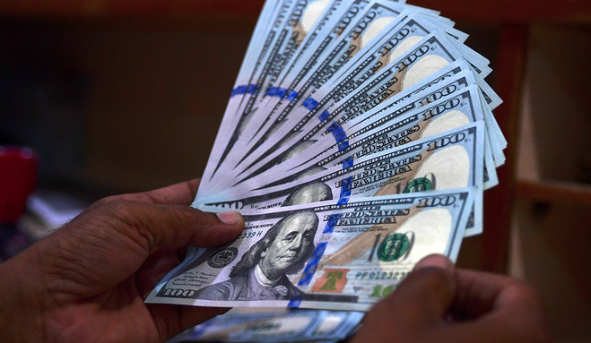 A foreign currency dealer counts US dollar notes at a currency market in Karachi on July 19, 2022. (AFP/File)