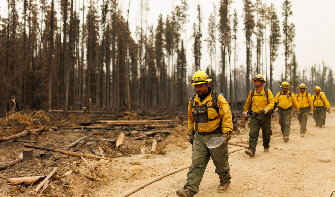 Firefighters from Mexico march along a fire guard as they battle wildfires in British Columbia, Canada, on July 13, that have scorched thousands of sqkm of land. (Reuters)