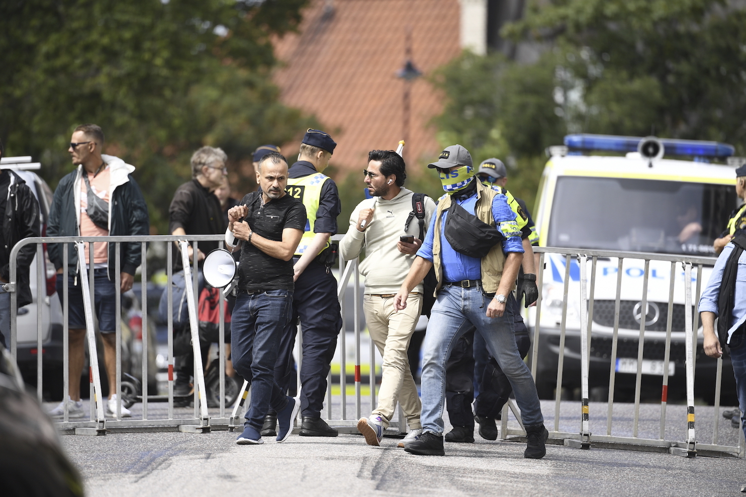 Protestor Salwan Momika is escorted by police to a location outside the Iraqi embassy in Stockholm where he desecrated a copy of the Quran. (AP)