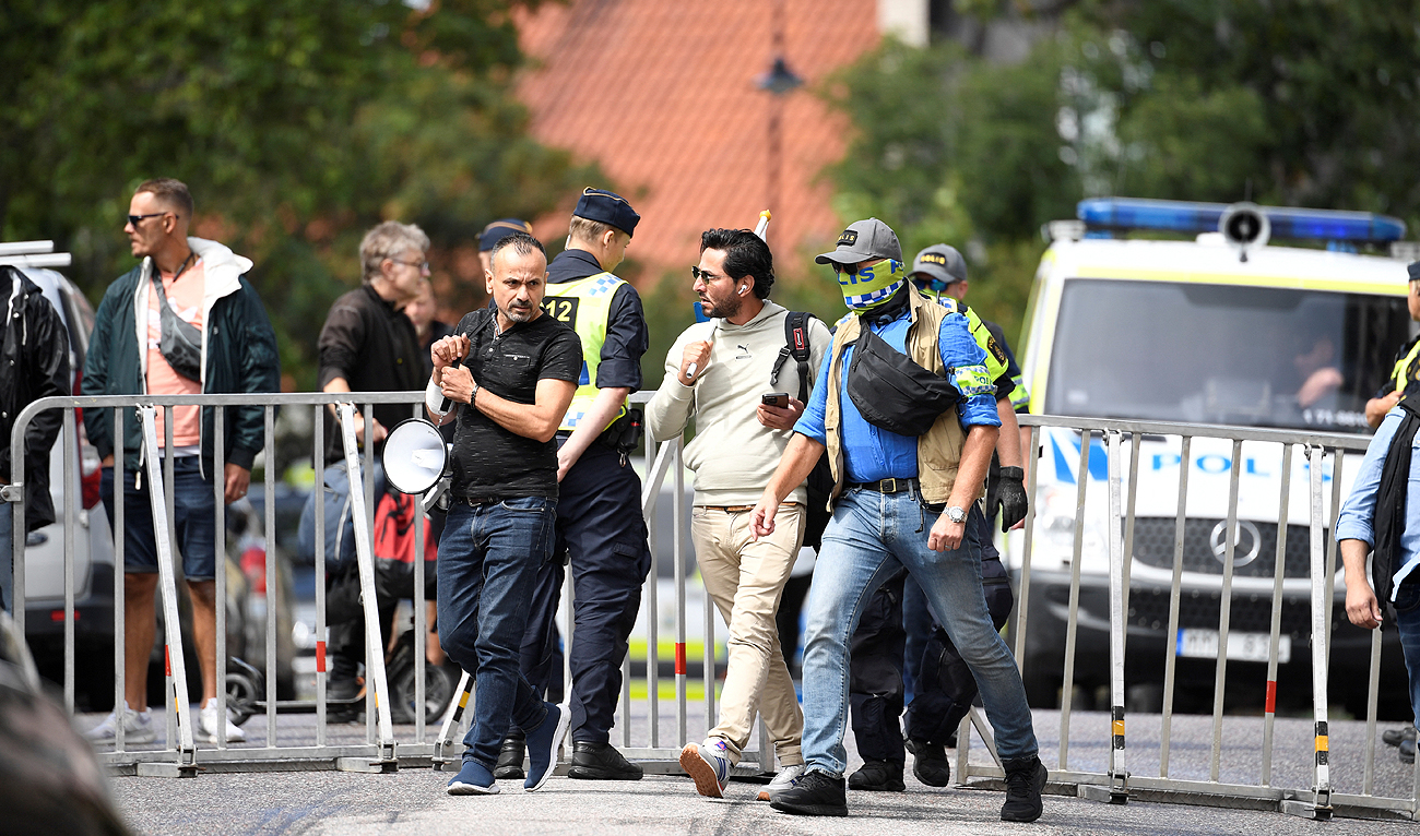 Protestor Salwan Momika, who planned to burn a copy of the Holy Qur'an and the Iraqi flag, is escorted by police to a location outside the Iraqi embassy, in Stockholm, Sweden July 20, 2023. (REUTERS)