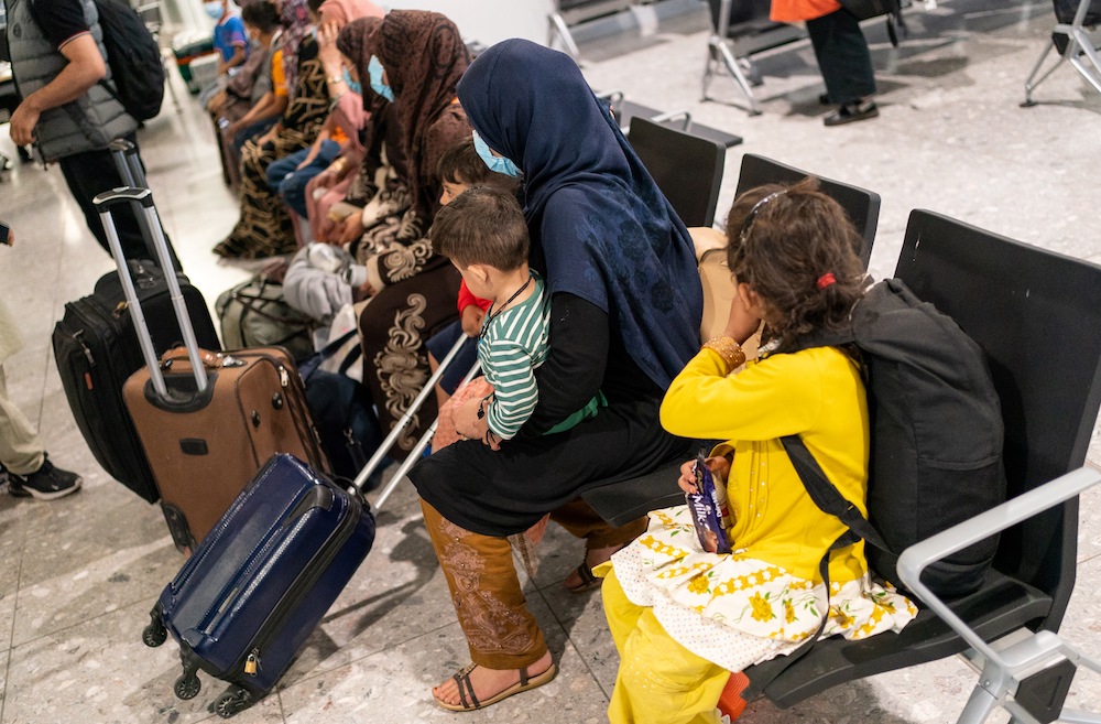 Afghan refugees wait to be processed after arriving on an evacuation flight from Afghanistan at Heathrow airport on Aug. 26, 2021. Thousands of Afghans are living in temporary hotel accommodation, at great cost to the UK taxpayer. (AFP file photo)