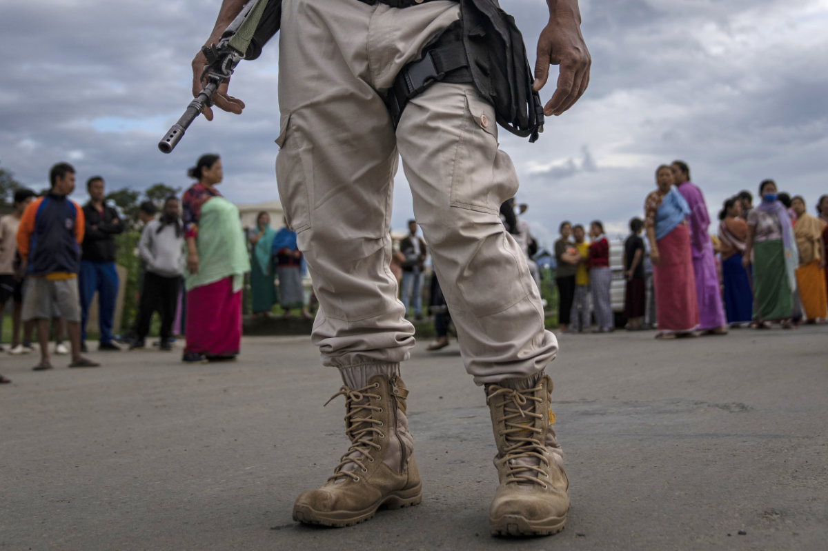 A Manipur policeman stands guard as members of Meira Paibis, powerful vigilante group of Hindu majority Meitei women, block traffic to check vehicles for members from rival tribal Kuki community, in Imphal, capital of the northeastern Indian state of Manipur, Monday, June 19, 2023. (AP)
