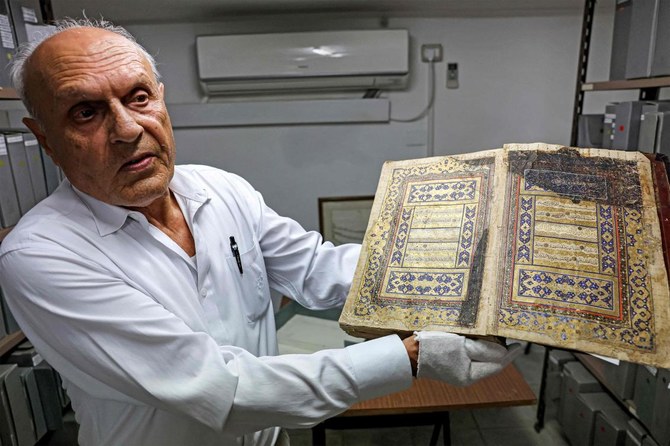 Palestinian Khader Salameh the librarian of the Khalidi library in the headquarters of the library which located in the chain road at the old city of Jerusalem showing a gilded copy of the Koran, Islam's holy book, dates back to the 16 century (AFP)