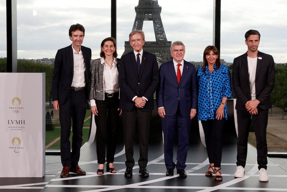 From left, Antoine Arnault, Amelie Oudea-Castera, Bernard Arnault, Thomas Bach, Anne Hidalgo and Tony Estanguet, pose during a press conference to announce a sponsorship deal for the Paris 2024 Olympic Games at the Grand Palais Ephemere in Paris on Monday. (Reuters)