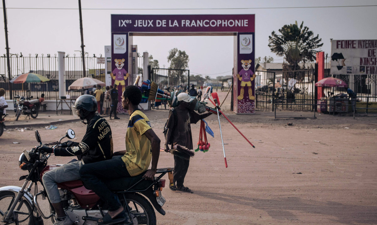 Residents walk past the entrance to one of the facilities of the 9th Jeux de la Francophonie in Kinshasa Tuesday. The 9th Francophone Games, a gathering of some 3,000 young athletes and artists from some 30 countries, opens Friday in Kinshasa. (AFP)