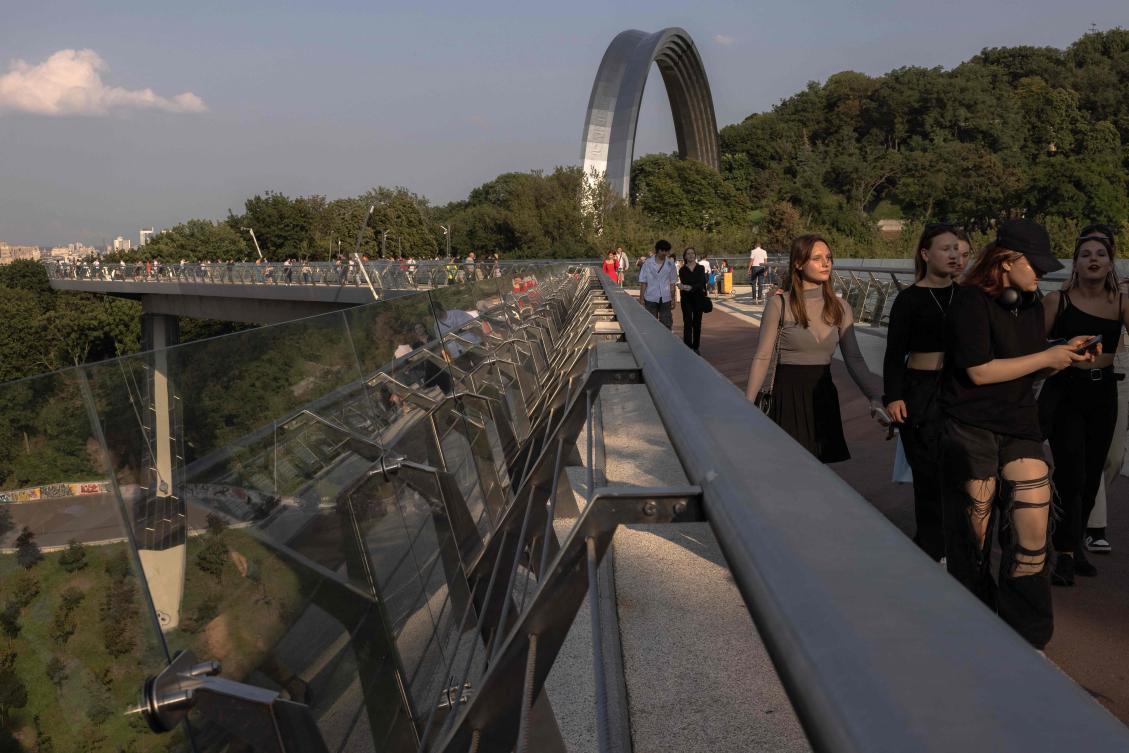 Members of the public visit a pedestrian bridge overlooking the Dnipro River and the city of Kyiv on July 25, 2023. (AFP)