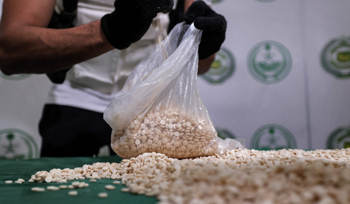 An officer of the Directorate of Narcotics Control of Saudi Arabia's Interior Ministry empties a bag of tablets of captagon seized during a special operation in the Red Sea coastal city of Jeddah. (AFP file photo)