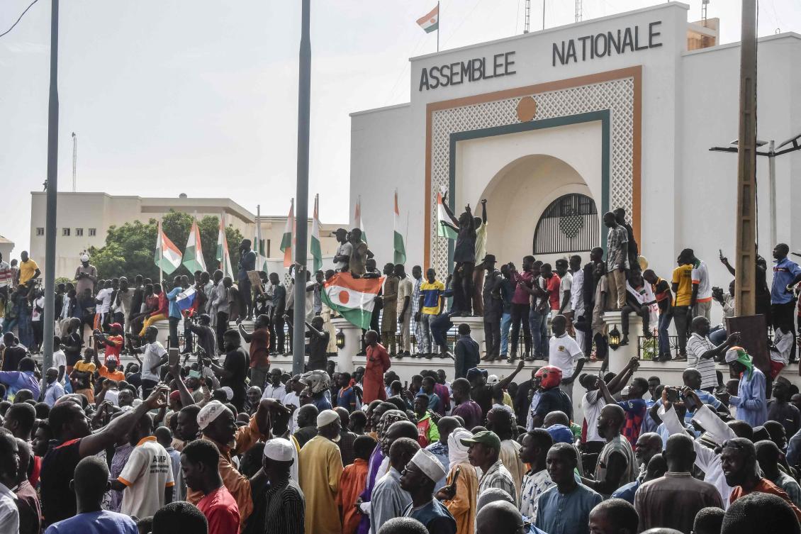 Supporters wave Nigerien’s flags as they rally in support of Niger’s junta in front of the National Assembly in Niamey on July 30, 2023. (AFP)