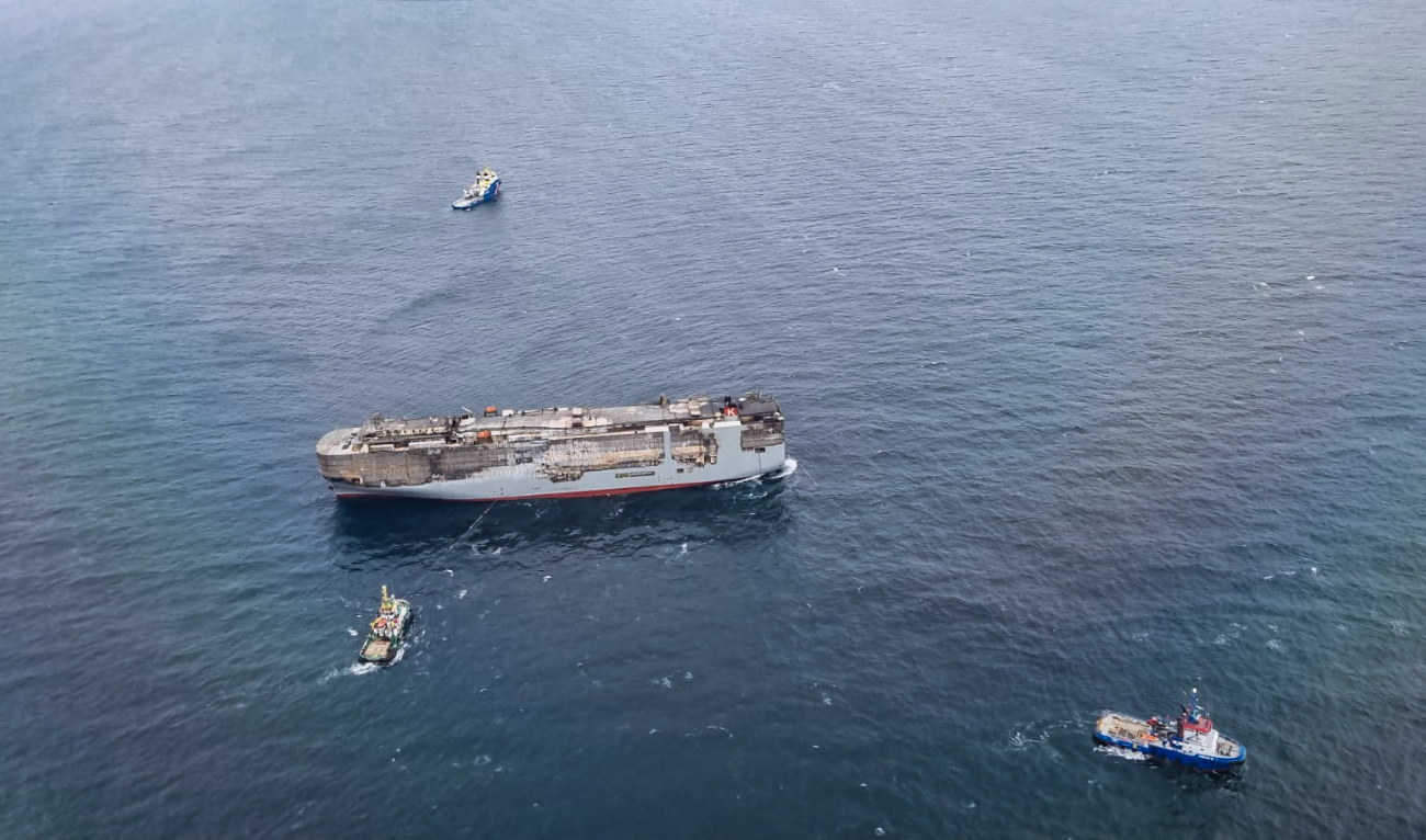 Panamanian-registered car carrier ship Fremantle Highway being towed on July 31, 2023 after a fire broke out late on July 25, 2023, killing one crew member, and prompting a massive effort to extinguish the flames. (AFP)