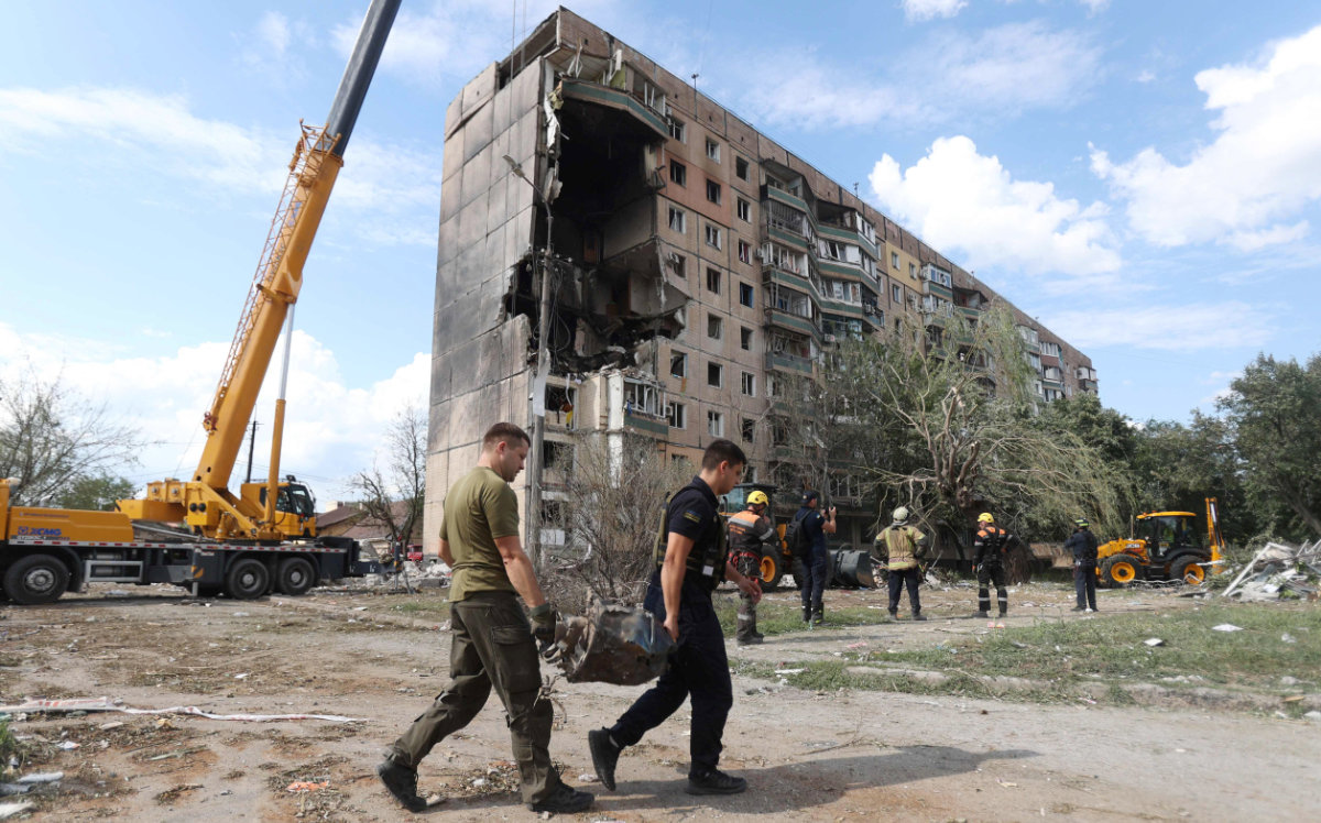 Rescuers carry a fragment of missile outside a nine-storey residential building partially destroyed as a result of Russian missiles strike in Kryvyi Rig on July 31, 2023, amid the Russian invasion of Ukraine. (AFP)