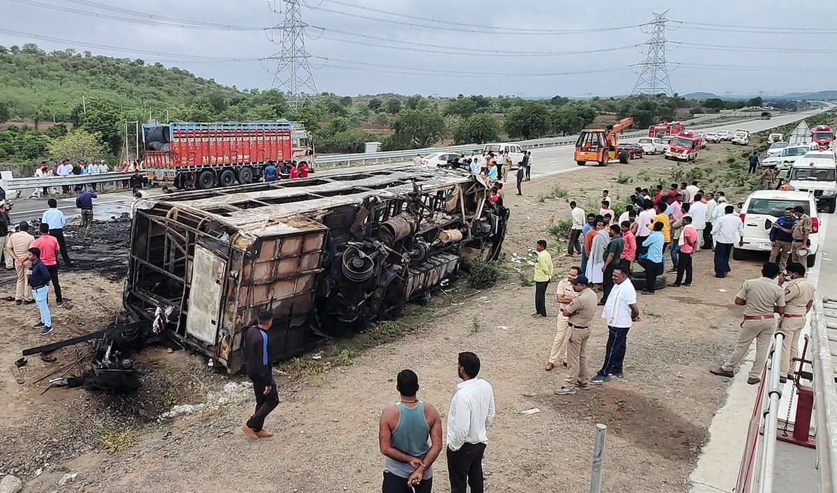 People gather around the wreckage of a bus that caught fire along the Samruddhi Expressway near Sindkhed Raja in Buldhana district of Maharashtra state on July 1, 2023. (AFP)